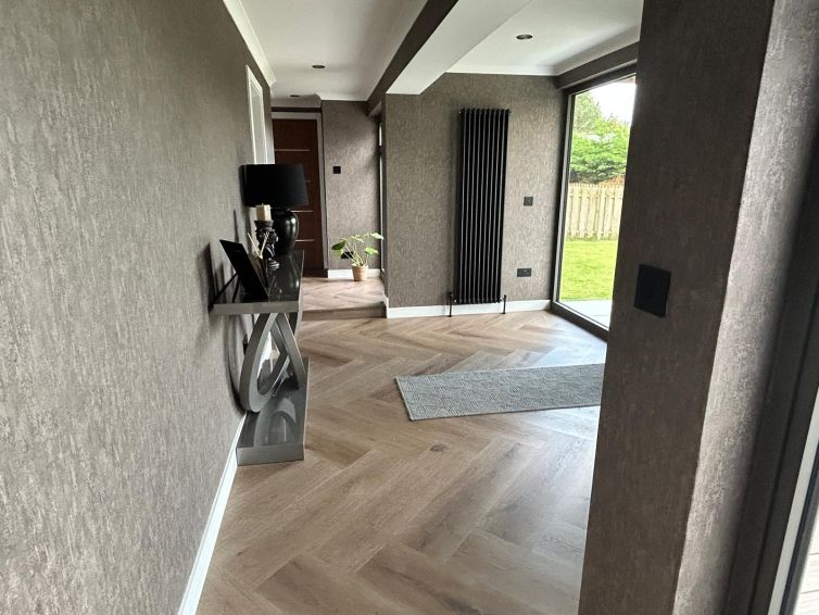 Open-plan living space with herringbone flooring and garden access