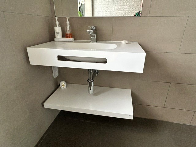 Wall-mounted basin and shelf installed in a residential wet room